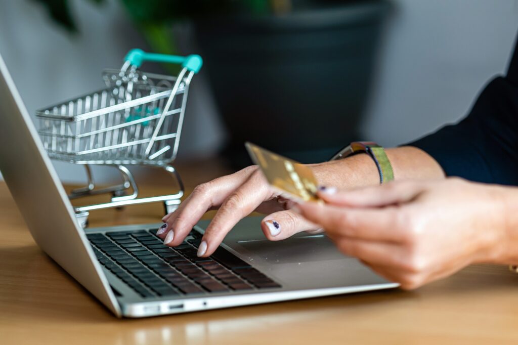 close-up of a woman hands buying online with a credit card and a laptop, e-commerce concept